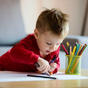 Child drawing with pencil crayons