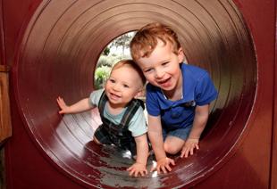 Early years and childcare - Young boys playing in a tunnel