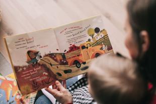 Early years and childcare - young child reading with woman