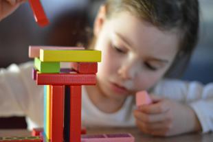 Early years and childcare - young girl playing with building blocks