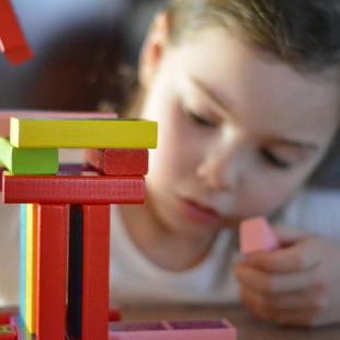 Early years and childcare - young girl playing with building blocks