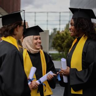 Three students with their degrees